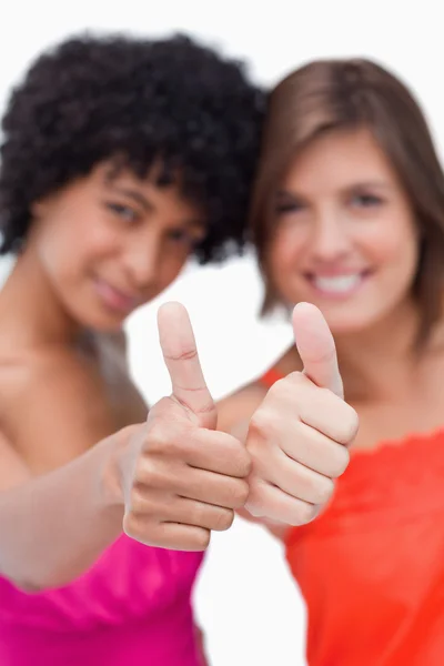 Tummen upp visade två glada tonåriga flickor — Stockfoto