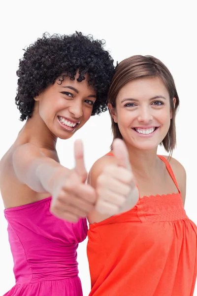 Lächelnde Teenager-Mädchen zeigen stolz ihre Daumen nach oben gegen eine — Stockfoto