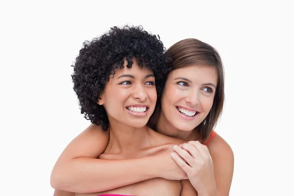 Smiling teenagers looking on the side while hugging each other — Stock Photo, Image