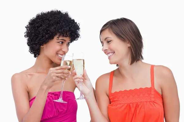 Jonge vrouwen rammelende glazen van champagne terwijl glimlachen — Stockfoto