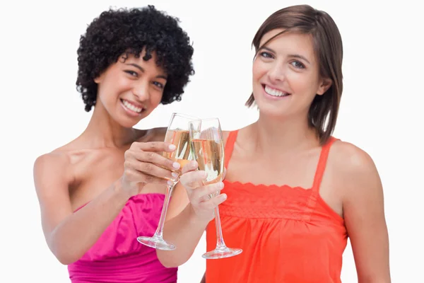 Unga kvinnor firar en händelse av spottar glas champagn — Stockfoto