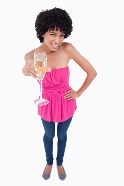 Mujer joven sonriendo mientras sostiene una copa de vino blanco —  Fotos de Stock