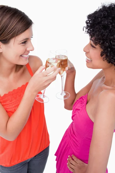 Две молодые женщины, стоящие лицом к лицу, звоня в стакан — стоковое фото