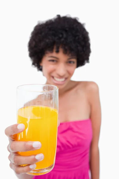 Glas apelsinjuice hålls fram av en attraktiv teenage — Stockfoto