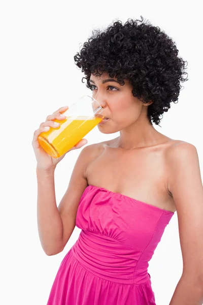 Adolescente relaxado bebendo um copo de suco de laranja — Fotografia de Stock