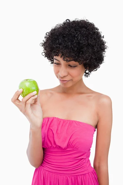 Молодая женщина смотрит на ее вкусное зеленое яблоко — стоковое фото