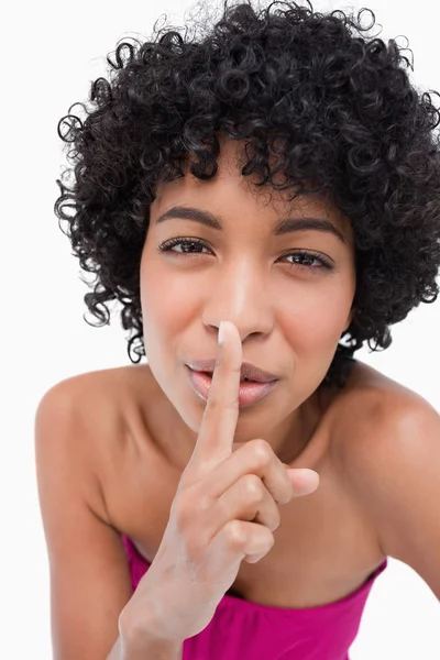 Beautiful teenage placing her finger in front of her mouth to as — Stock Photo, Image