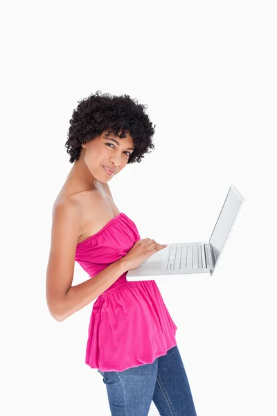 Young woman looking at the camera while using the touchpad of he — Stock Photo, Image