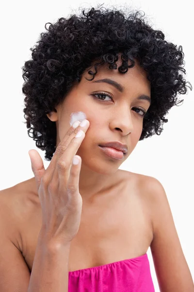 Young woman applying cream to her face — Stock Photo, Image
