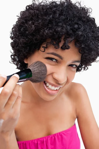 Adolescente usando uma escova de pó para aplicar maquiagem — Fotografia de Stock