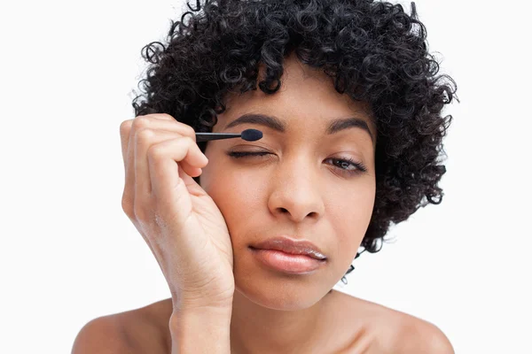 Jovem mulher aplicando maquiagem enquanto colocava sombra nos olhos — Fotografia de Stock