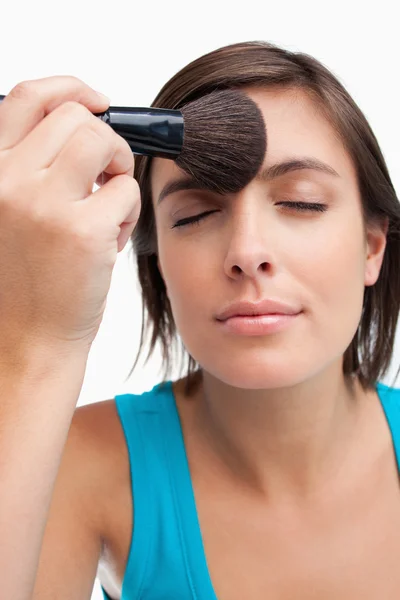 Joven mujer tranquila cerrando los ojos mientras se aplica maquillaje —  Fotos de Stock