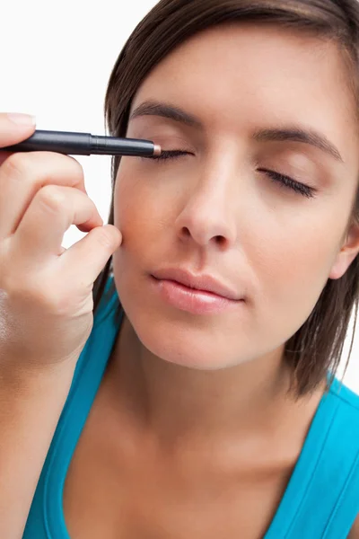 Νεαρή γυναίκα χρησιμοποιώντας ένα μολύβι ματιών για την εφαρμογή make-up — Φωτογραφία Αρχείου