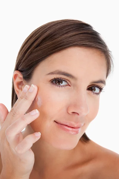 Tiener toepassing crème op haar gezicht met haar vingers — Stockfoto
