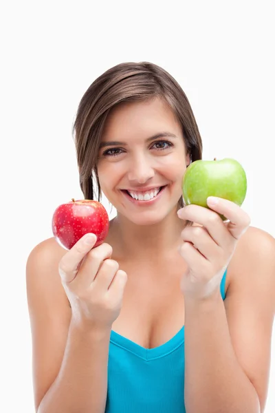 Uśmiechnięta młoda kobieta trzyma dwa jabłka — Zdjęcie stockowe