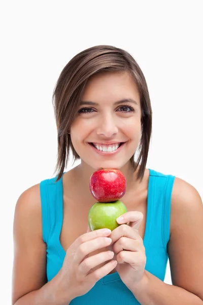 Adolescente sorrindo e segurando duas maçãs entre as mãos e ele — Fotografia de Stock