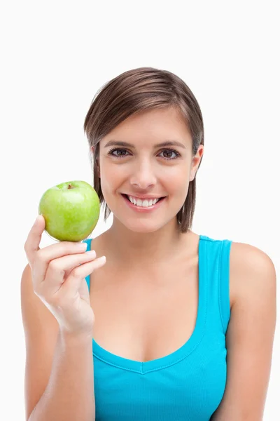 Young woman holding a green apple in her right hand — Stock Photo, Image