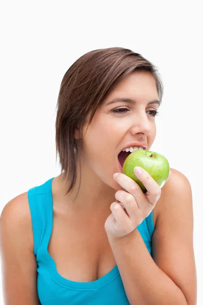 少年一边看一边吃着一个绿色的苹果 — 图库照片