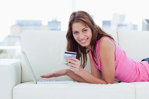 Ung kvinna med ett kreditkort samtidigt visar ett stort leende — Stockfoto