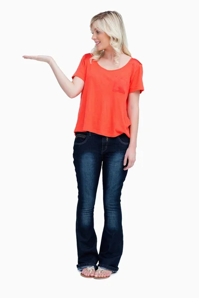 Smiling teenager standing upright with her hand palm up — Stock Photo, Image