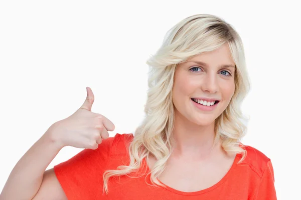 Lächelnde junge blonde Frau, die einverstanden ihre Daumen nach oben streckt — Stockfoto