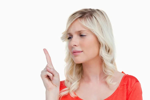 Atrakcyjna młoda kobieta, podnoszenie jej palcem w powietrzu — Zdjęcie stockowe