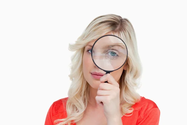 Fair-haired woman looking through a magnifying glass — Stock Photo, Image