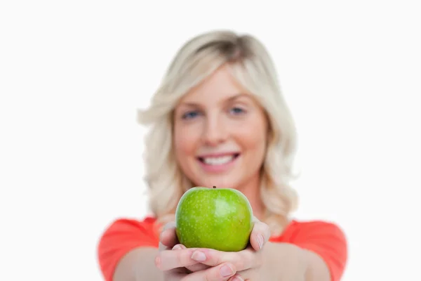Зеленое яблоко, которое держит привлекательная женщина, скрестившая руки — стоковое фото