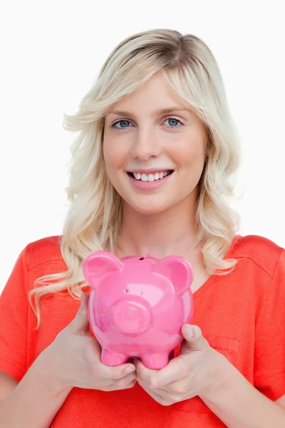 Glimlachend tienermeisje bedrijf een roze piggy bank in haar handen — Stockfoto