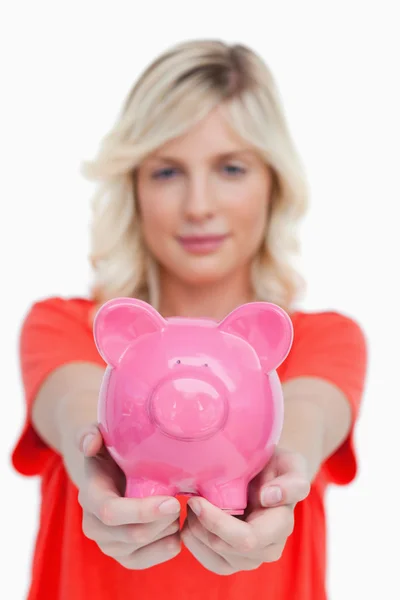 Piggy bank rosa realizada por uma jovem mulher — Fotografia de Stock