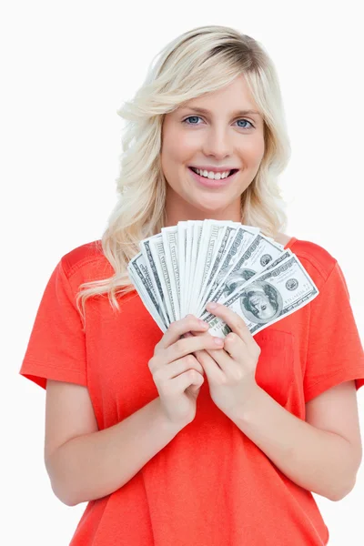 Young attractive woman holding dollar notes in a fan shape — Stock Photo, Image