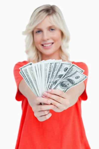 Jest fanem notatki dolara w posiadaniu uśmiechający się atrakcyjną kobietą — Zdjęcie stockowe