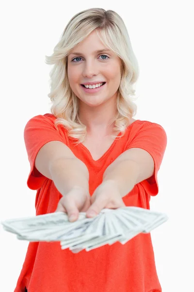 Mulher sorridente segurando um fã de notas de dólar em suas mãos — Fotografia de Stock