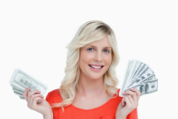 Smiling woman holding two fans of dollar notes in her hands — Stock Photo, Image