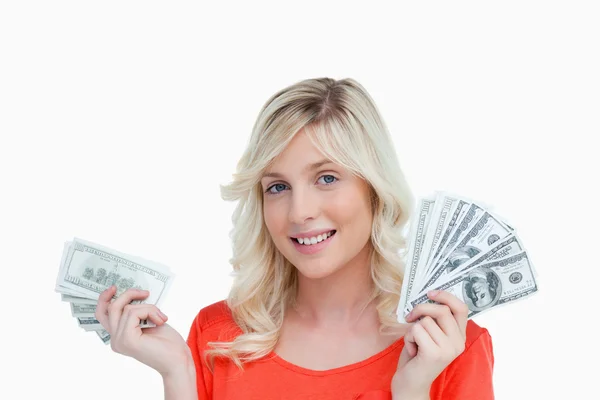 Γυναίκα που δείχνει ένα μεγάλο χαμόγελο, κρατώντας δύο οπαδούς του δολαρίου δεν — Φωτογραφία Αρχείου