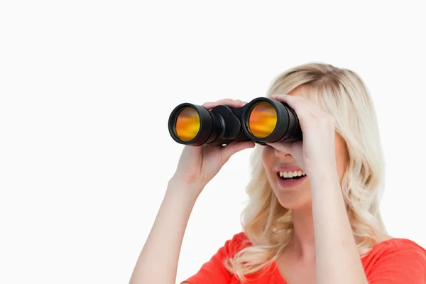 Sorridente donna attraente guardando con binocolo — Foto Stock