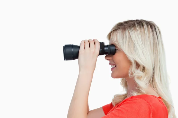 Side view of an attractive woman looking through binoculars — Stock Photo, Image