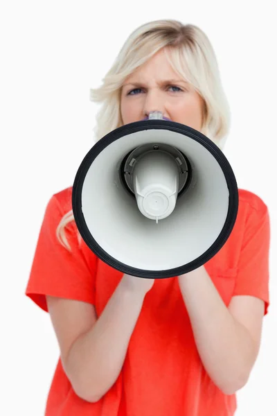 Woman looking upset while speaking into a megaphone — Stock Photo, Image
