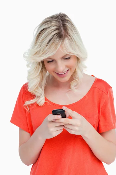 Lächelnde Frau, die mit ihrem Handy eine SMS verschickt — Stockfoto