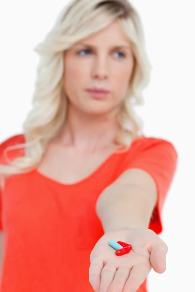 Rote und blaue Vitamine in der Hand einer jungen Frau — Stockfoto