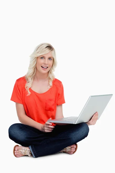 Fiatal nő ül, cross-legged holding vele laptop — Stock Fotó