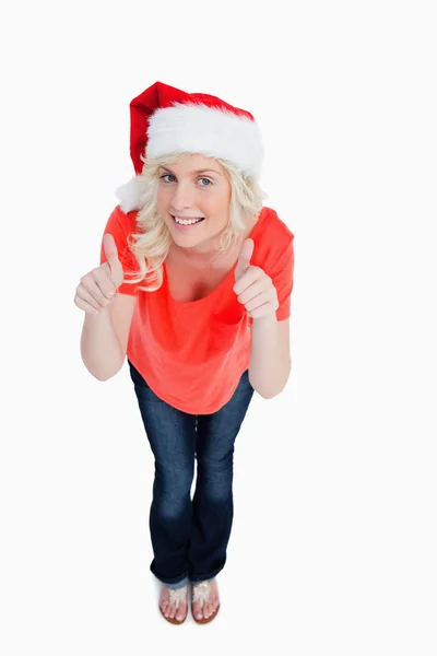 Светловолосая женщина, поднимающая большие пальцы на Рождество — стоковое фото