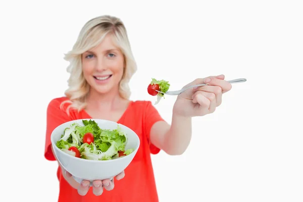 Tigela branca de salada de legumes realizada por uma jovem mulher loira — Fotografia de Stock
