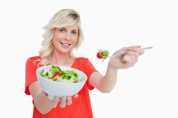 Mujer rubia joven sosteniendo un tazón de ensalada fresca — Foto de Stock