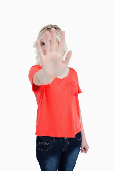 Young blonde woman trying to hide herself behind her hand — Stock Photo, Image