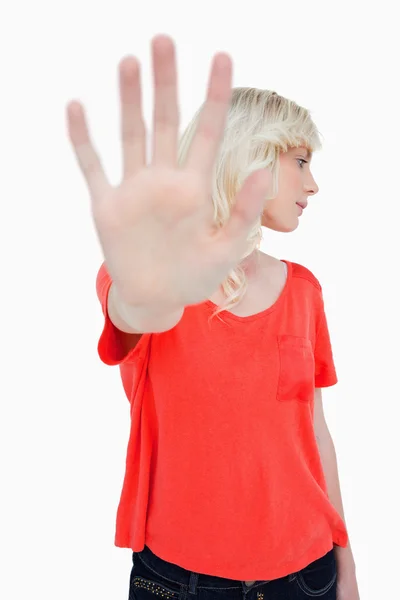 Junge Frau, die das Stoppschild mit der Hand macht, während sie ihre Hea lehnt — Stockfoto