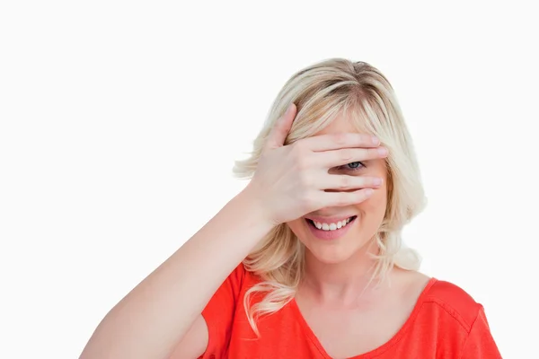 Mujer joven tratando de ver a través de sus dedos colocados frente a — Foto de Stock