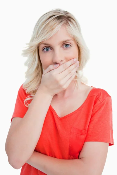 Blonde woman covering her mouth with her hand — Zdjęcie stockowe