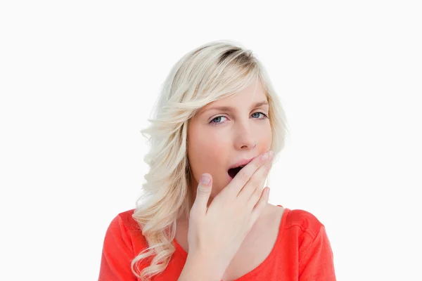Jonge blonde vrouw geeuwen en die betrekking hebben op haar mond met haar hand — Stockfoto
