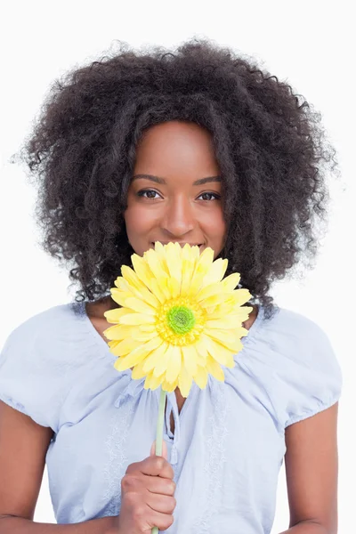 Tonårsflicka gömmer hennes mun bakom en gul blomma — Stockfoto